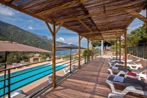 波尔图Villa Kalliste的一个带椅子和遮阳伞的游泳池的度假酒店