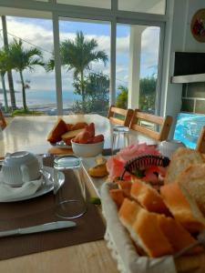 Rodrigues IslandLa Terrasse的桌子上摆着面包和其他食物,上面摆着大海