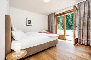 沃尔特湖畔韦尔登Appartements Schwarzvilla的一间卧室设有一张床和一个大窗户