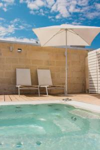 莱切苏伊特提豪华客房旅馆的游泳池旁的一把遮阳伞和两把椅子