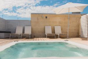 莱切苏伊特提豪华客房旅馆的一个带两把椅子和遮阳伞的游泳池