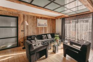 蒂涅Les Suites – Maison Bouvier的带沙发和玻璃桌的客厅