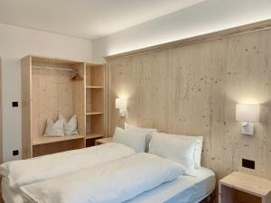 坎皮泰洛迪法萨欧式公寓的一间卧室配有带白色床单和枕头的床。