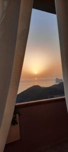 内比达Vista Sul Pan di Zucchero - Nebida - Holiday House的从大楼的窗户欣赏日落美景