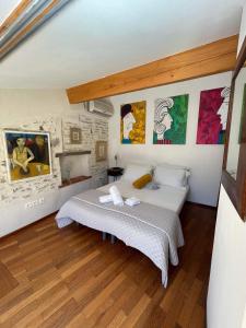 科利尤尔Fenêtre sur Collioure的卧室配有一张床,墙上挂有绘画作品