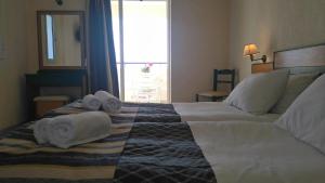 斯卡拉Porto Skala Hotel Village的酒店客房,配有带毛巾的床