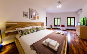 Marano di ValpolicellaMaregnago Relais的一间卧室配有一张大床和木制床头板