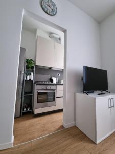 米兰Claro Apartments - Prampolini 12的白色的厨房配有炉灶和电视。