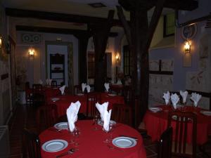 奥尔梅多格兰波萨达拉米思那达酒店的餐厅设有红色的桌椅和餐巾