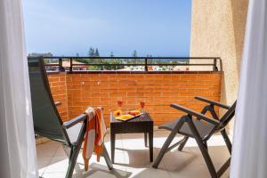 英格兰海滩大加那利岛穆尔海王星酒店 - 仅限成人入住的阳台配有两把椅子和一张带水果的桌子。