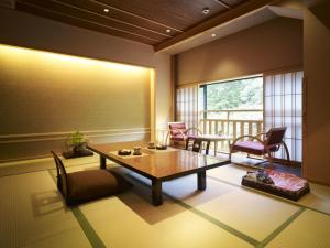 泉佐野不动口馆日式旅馆的一间带桌椅的客厅和一个阳台