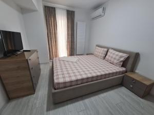 布加勒斯特Apartament Moghioros Park Residence DUM1的一间小卧室,配有一张床和电视