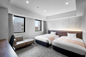 札幌Daiwa Roynet Hotel Sapporo Nakajima Koen的一间卧室配有两张床、椅子和两个窗户。