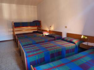 基亚文纳Ostello Al Deserto的一间酒店客房,房间内设有三张床