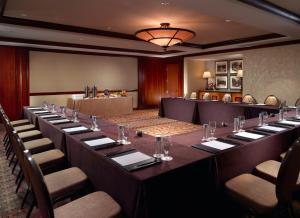 圣安东尼奥莫卡拉Spa酒店的大型会议室,配有长桌子和椅子
