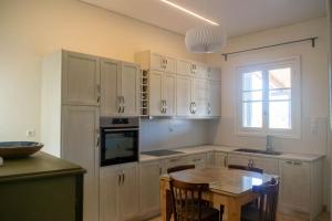 美西尼G&N APARTMENT的厨房配有白色橱柜、桌子和窗户。