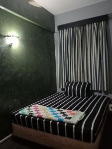 波德申GLORY Beach Resort private 2 bedroom apartment的一间卧室配有一张黑色墙壁的床