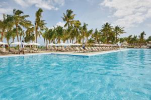 南威Hotel Riu Jambo - All Inclusive的度假村的游泳池,配有椅子和遮阳伞