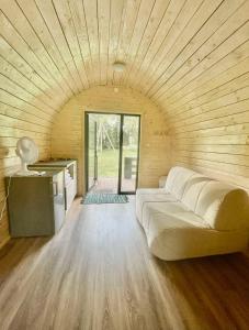 帕卢舍Palūšės Kempingas (nameliai)的一间设有木制天花板的客房内的一张白色大沙发