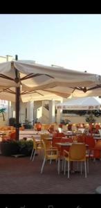 卡斯特拉巴特滨海Casa Villaggio的一间餐厅,配有桌椅,位于伞下