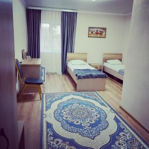 库斯塔奈Hotel Дар-Ай的一间设有两张床的房间和一张地毯