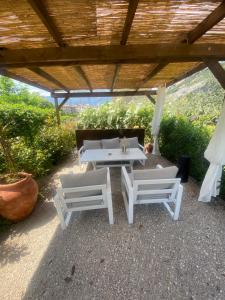 托尔博莱Casa 32的庭院配有2张白色桌子和沙发
