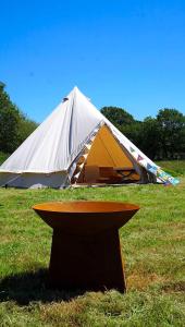 Corfe MullenDorset Glamping Fields的草原上的帐篷,有桌子