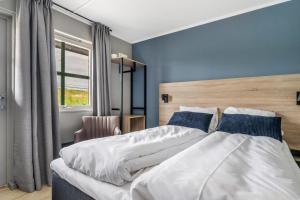 RingsakerFrich's Rudshøgda的一间卧室配有一张带蓝色墙壁的大床