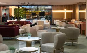 普罗夫迪夫The Emporium Plovdiv - MGALLERY Best Luxury Modern Hotel 2023的大堂配有沙发和桌椅