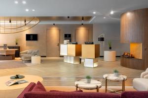 普罗夫迪夫The Emporium Plovdiv - MGALLERY Best Luxury Modern Hotel 2023的大厅,在大楼里设有沙发和桌子