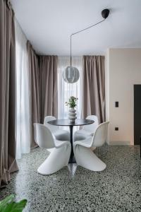 雅典The Artisan Suites的一间带桌子和白色椅子的用餐室