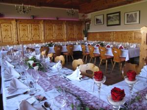 沃尔夫斯堡迪西伯格酒店的一间长餐厅,配有桌椅和红色玫瑰