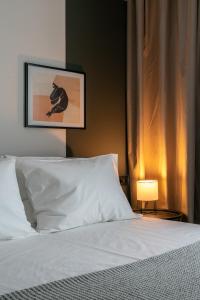 雅典The Artisan Suites的卧室配有白色的床和灯