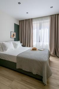 雅典The Artisan Suites的一间卧室配有床和带窗帘的窗户