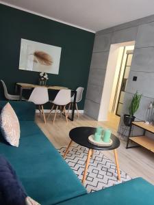比亚瓦波德拉斯卡Green Loft Apartament的客厅配有绿色沙发和桌子