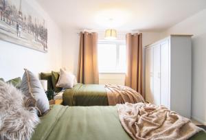 艾尔斯伯里Virexxa Aylesbury Centre - Deluxe Suite - 3Bed House with Free Parking的一间卧室设有两张床和窗户。