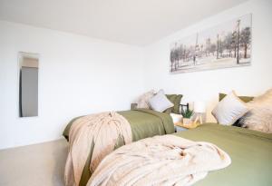 艾尔斯伯里Virexxa Aylesbury Centre - Deluxe Suite - 3Bed House with Free Parking的一间卧室配有两张绿色的床和毯子