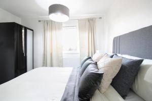 艾尔斯伯里Virexxa Aylesbury Centre - Deluxe Suite - 3Bed House with Free Parking的卧室配有白色的床和窗户。