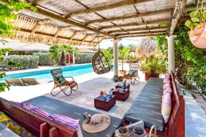 威利布罗德Kas Amigu accomodations的一个带桌椅的庭院和一个游泳池