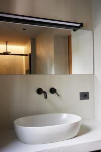 米兰马瑞提那Mima Aparthotel Boutique & Spa的浴室设有白色水槽和镜子