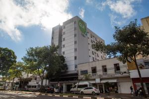 伊瓜苏伊瓜苏市CLH酒店的上面有绿色标志的高大的白色建筑