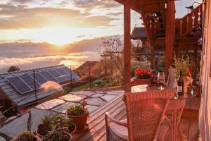 FerndorfDie Mirnockhütte的阳台配有桌椅,享有日落美景。
