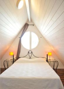 阿卡雄Lagrange Vacances - Résidence Jardin Mauresque的一间卧室配有一张带两盏灯的大型白色床。