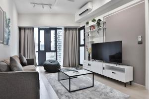 吉隆坡H&N Luxury Suites KLCC的一间带电视和沙发的客厅