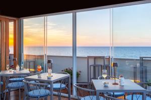 特拉帕尼拉甘夏住宅酒店的一间带桌椅的海景餐厅