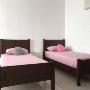 新山Homestay SKS Apartment Larkin Johor Bahru的两张睡床彼此相邻,位于一个房间里