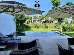 后川Villa Panda - Sanctuary Ho Tram Resort的一个带游泳池和遮阳伞的度假胜地