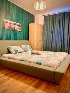 北马马亚-讷沃达里Arcadia Apartament Mamaia Nord的卧室内的一张床位,卧室设有绿色的墙壁