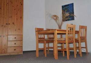 萨斯尼茨Pension Sassnitz Atelierhaus的木制餐桌,配有两把椅子和梳妆台