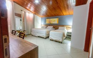 巴纳内拉斯Serra Golfe Apart Hotel的一间卧室设有两张床和木制天花板